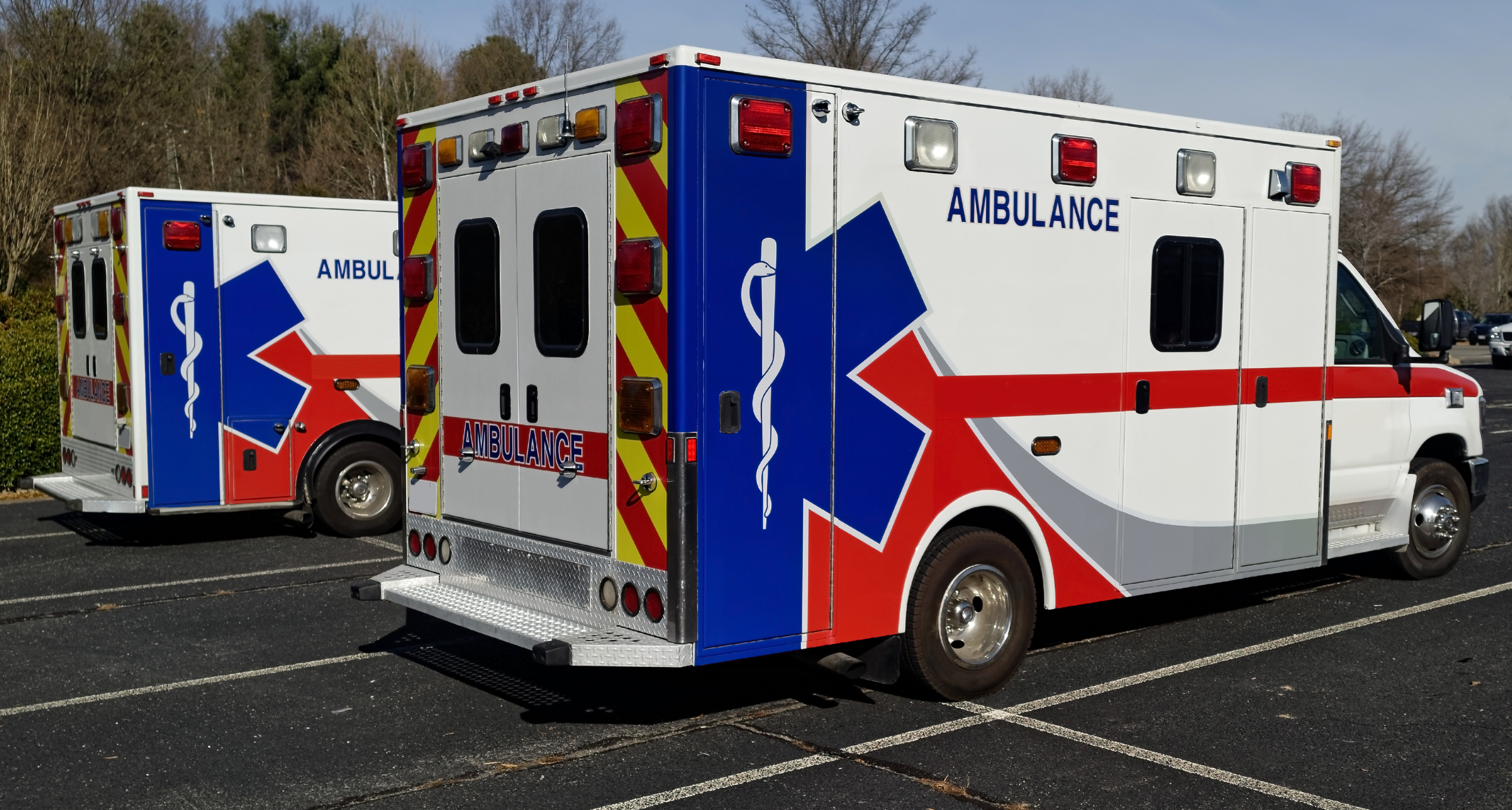 Side and rear view of two parked ambulances. Horizontal. JD Fulwiler