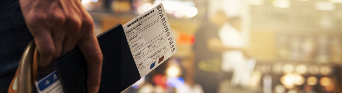Man holding a boarding pass in an airport.