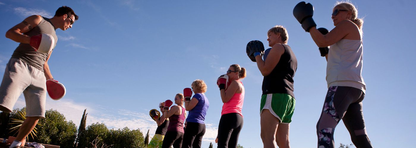 Six women wearing boxing gloves during a sports camp.